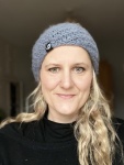 Me Laura wearing a beanie, with long blond hair. aged 45